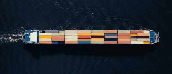 A container ship in the ocean that is carrying goods for supply chain & logistic companies