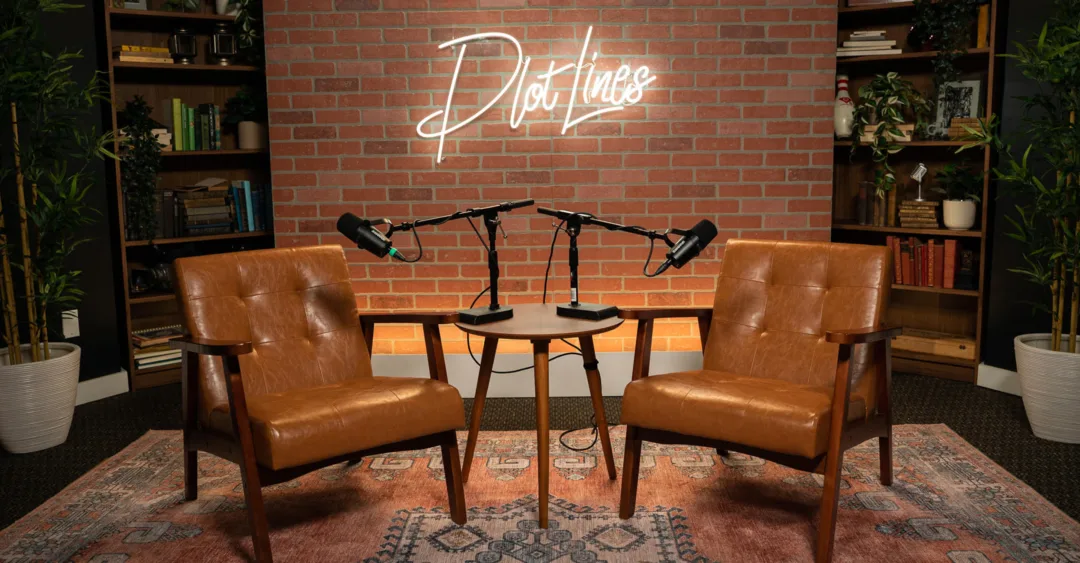 Podcast studio setup with two leather chairs and microphones beneath a PlotLines sign, representing a discussion on how hospitality principles are shaping modern residential living.