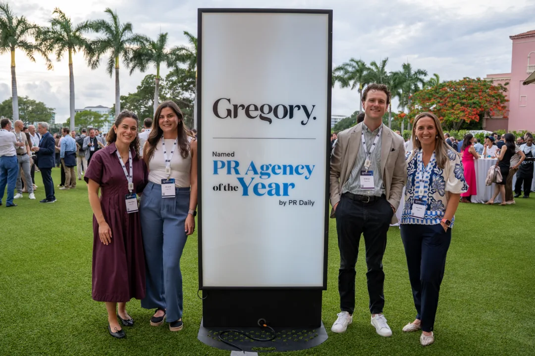 Gregory team members at Wealth Management EDGE 2026 in Boca Raton standing beside a sign recognizing Gregory as PR Daily Agency of the Year