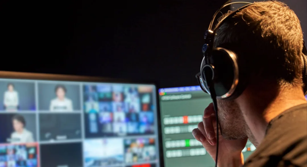 Man staring at computer screen with multiple news outlets playing